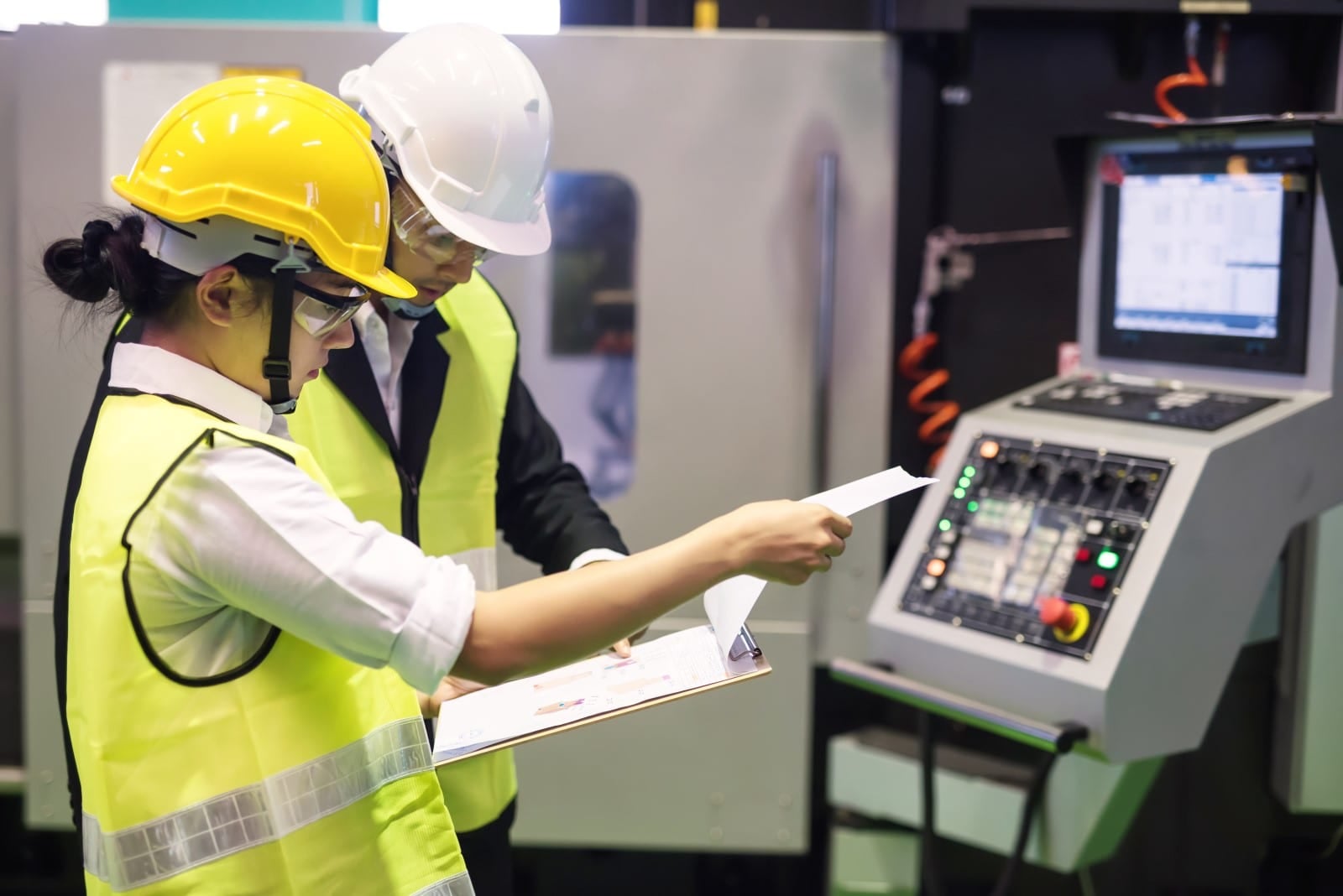 woman and man in hard hats looking at clipboard