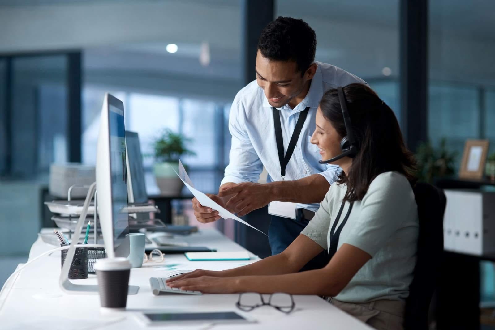 two colleagues looking at paper smiling