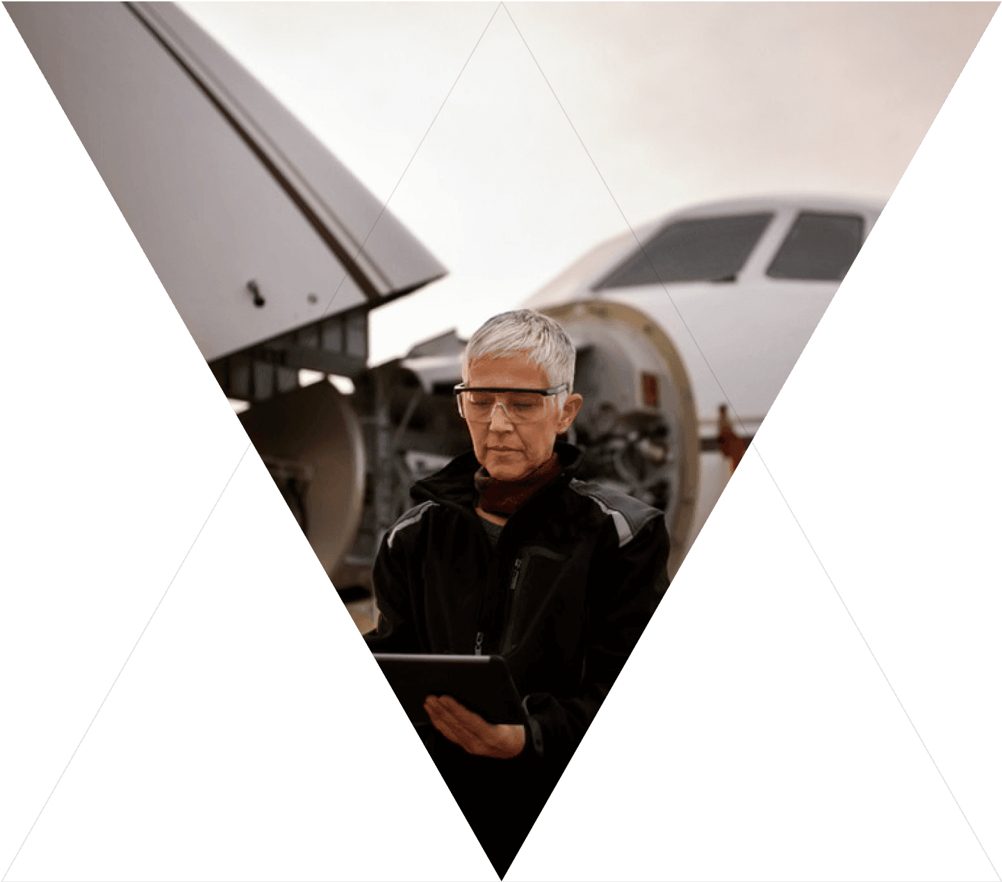 women looking at notpad by an aircraft being mantained