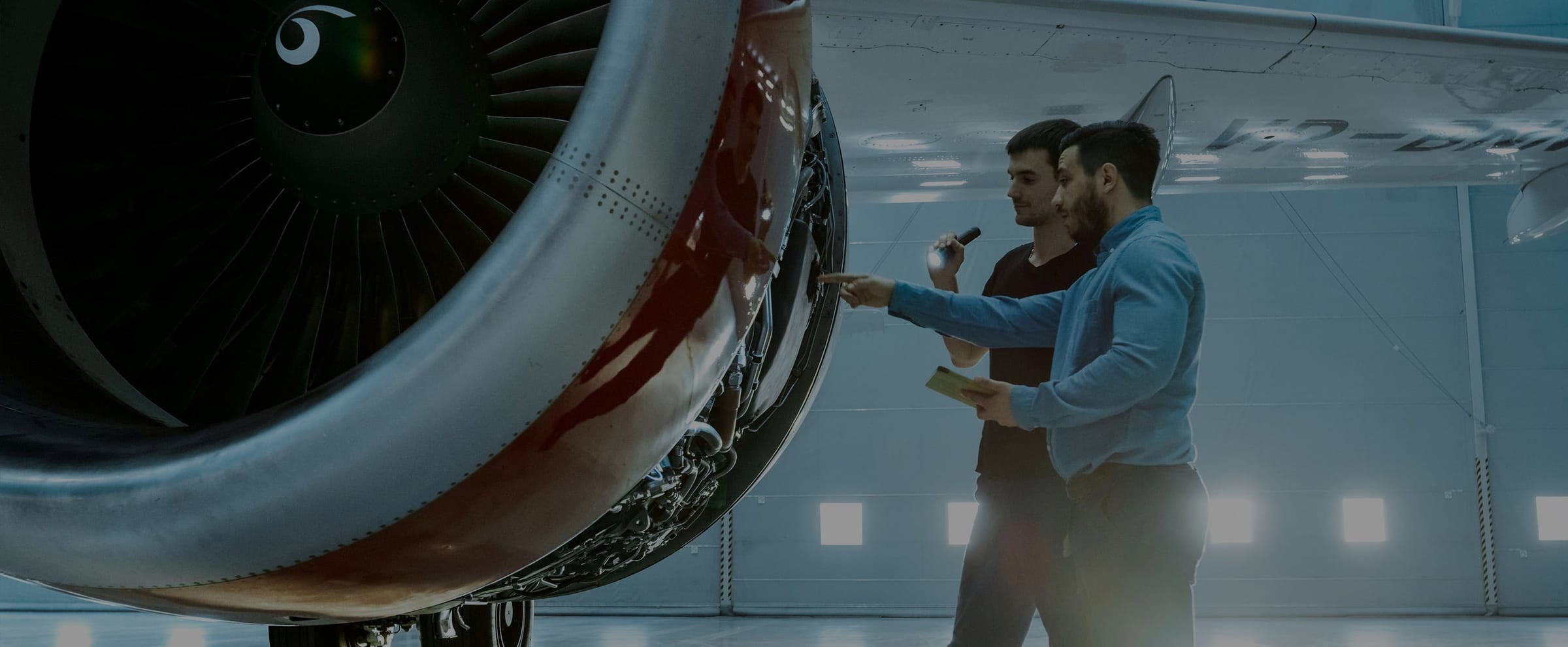 two men looking at aeroplane engine