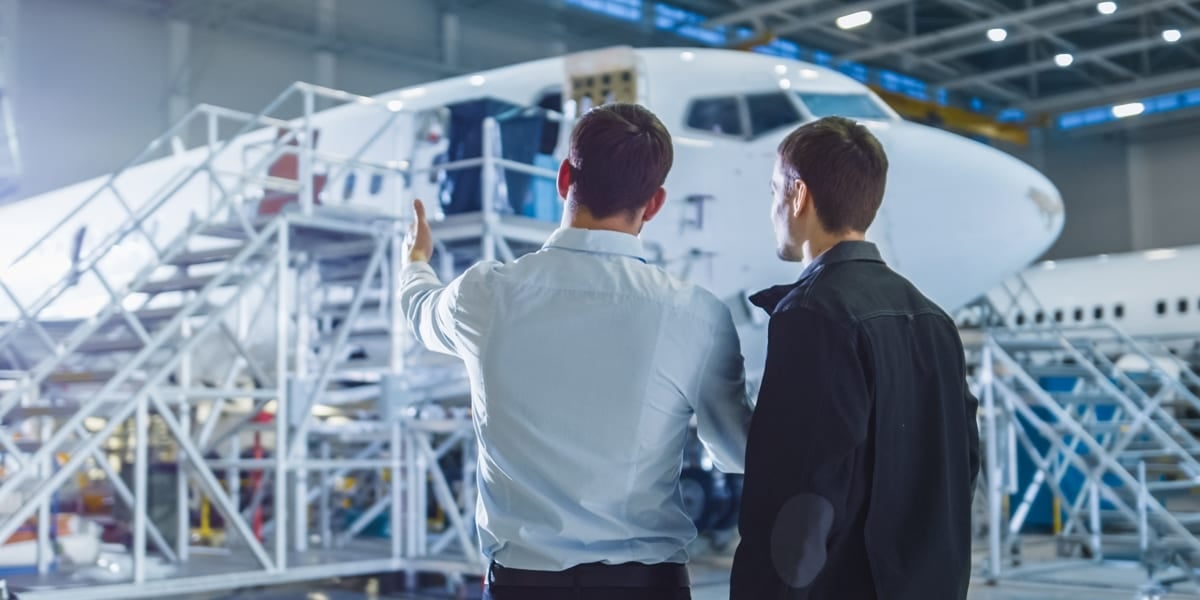 two men pointing to an aeroplane