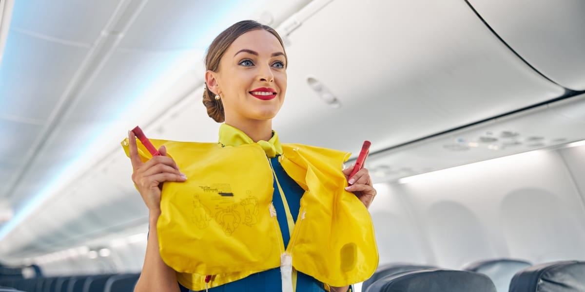 hostess demonstrating life vest in cabin