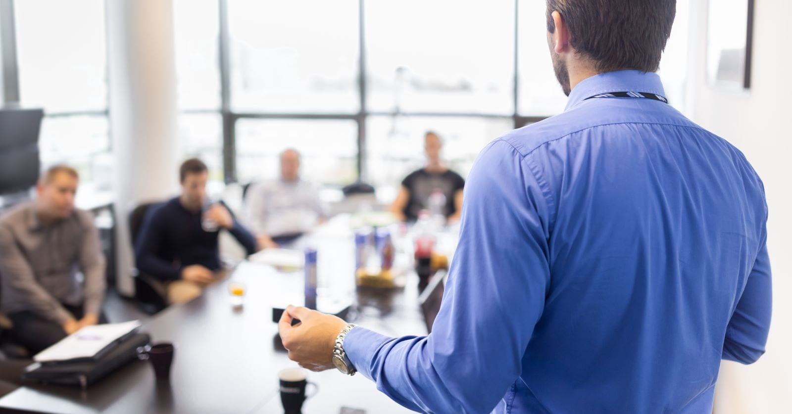 person standing up talking during a team meeting