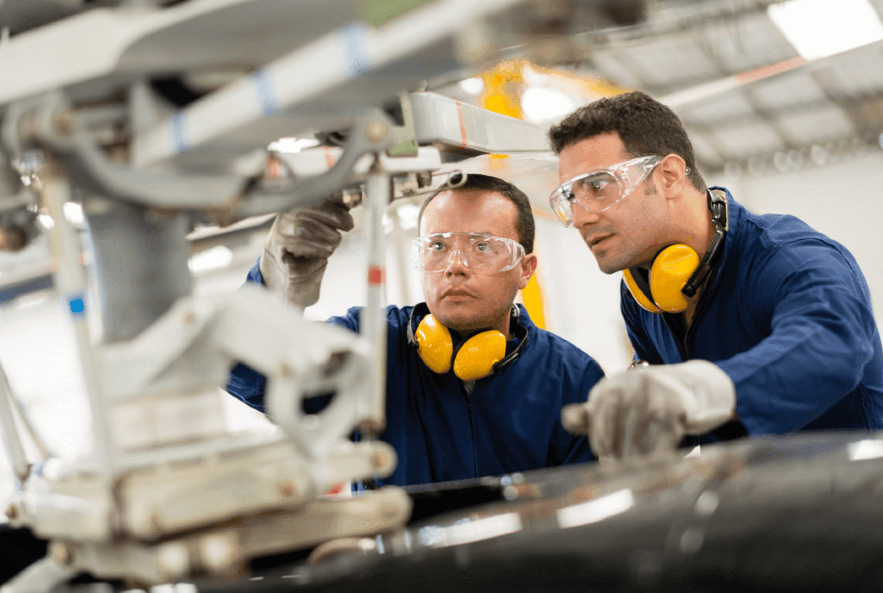 Two men dressed as engineers looking at machinery